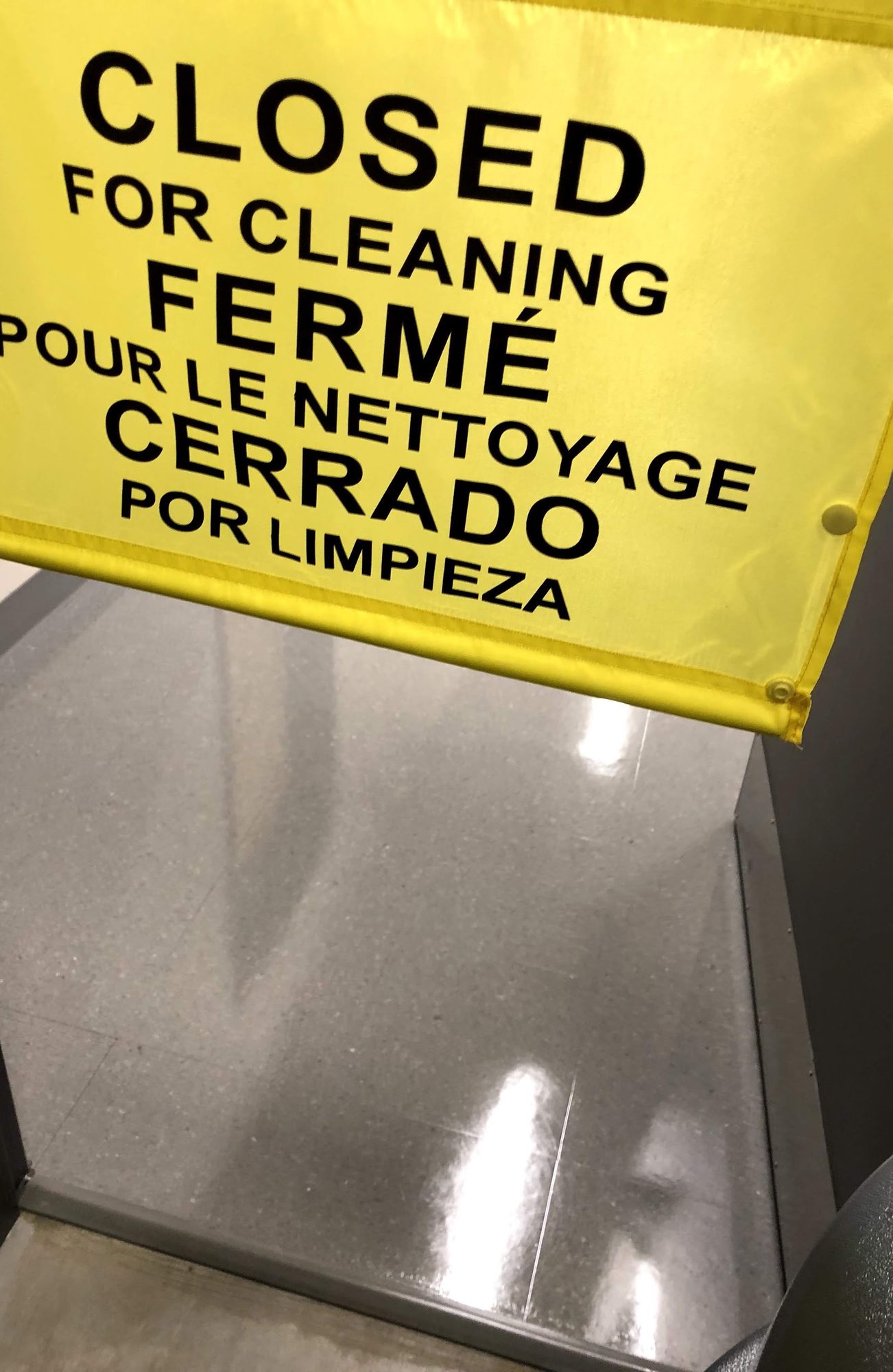 A yellow closed-for-cleaning sign hung over a freshly cleaned floor