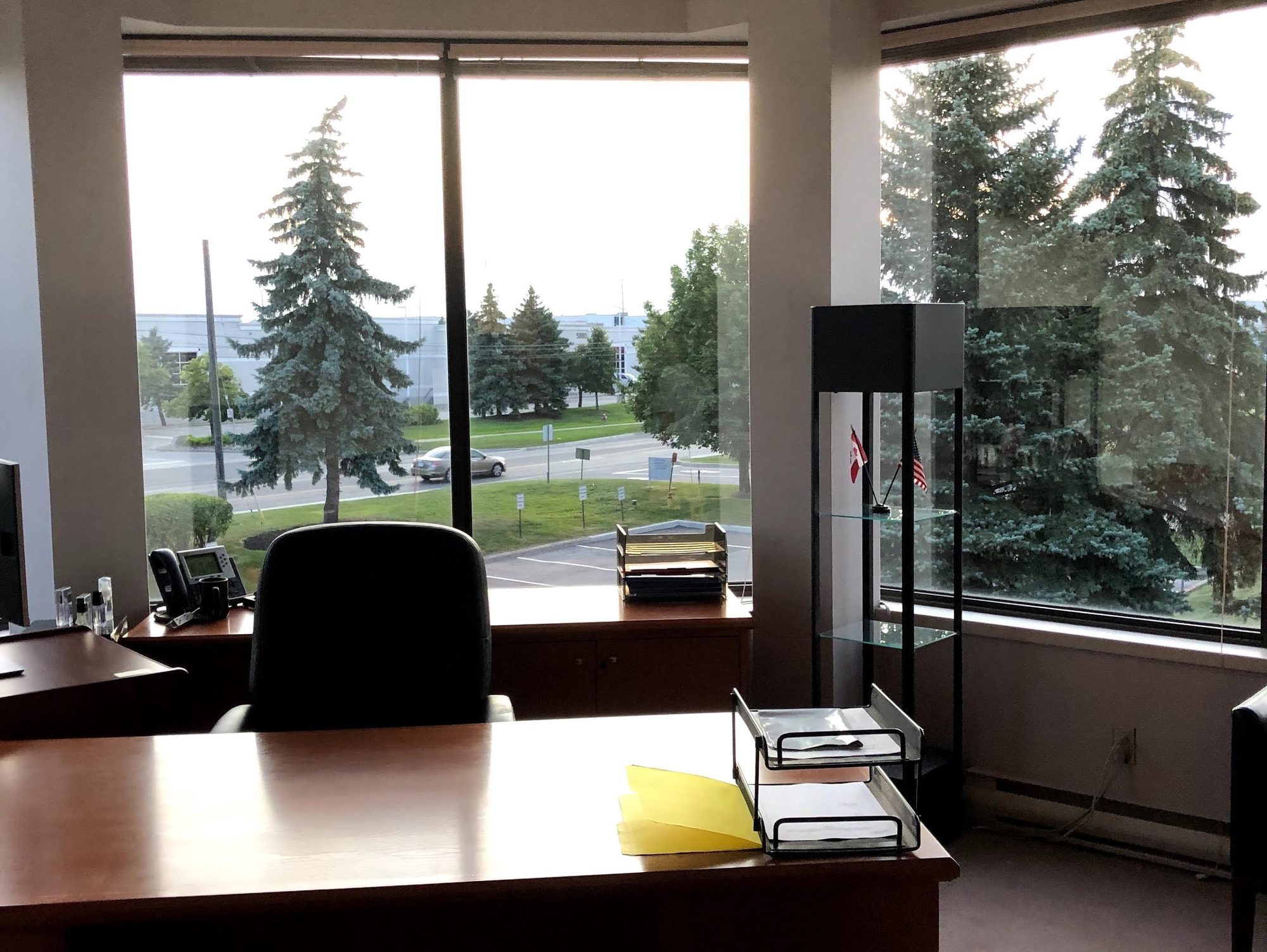 A cleaned private office with a desk and large windows at dusk